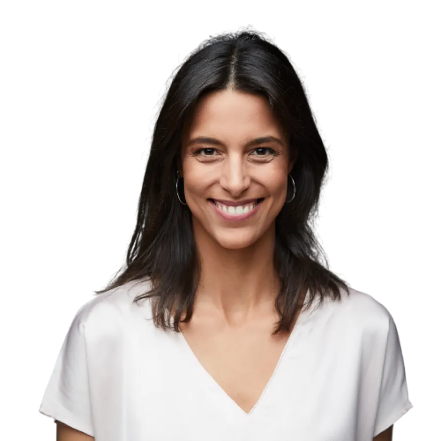 Smiling woman in a light blouse against a black background, showcasing natural beauty and confidence.