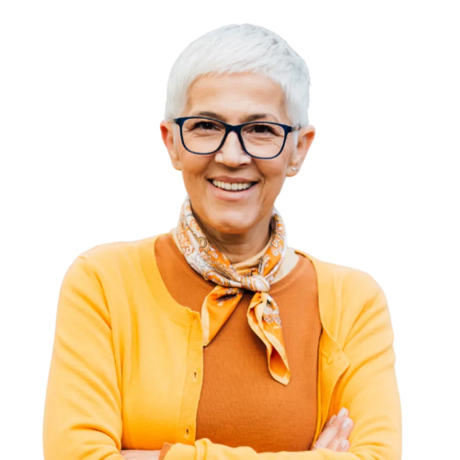 Smiling mature woman with short white hair, glasses, orange scarf, and yellow cardigan poses confidently with arms crossed.