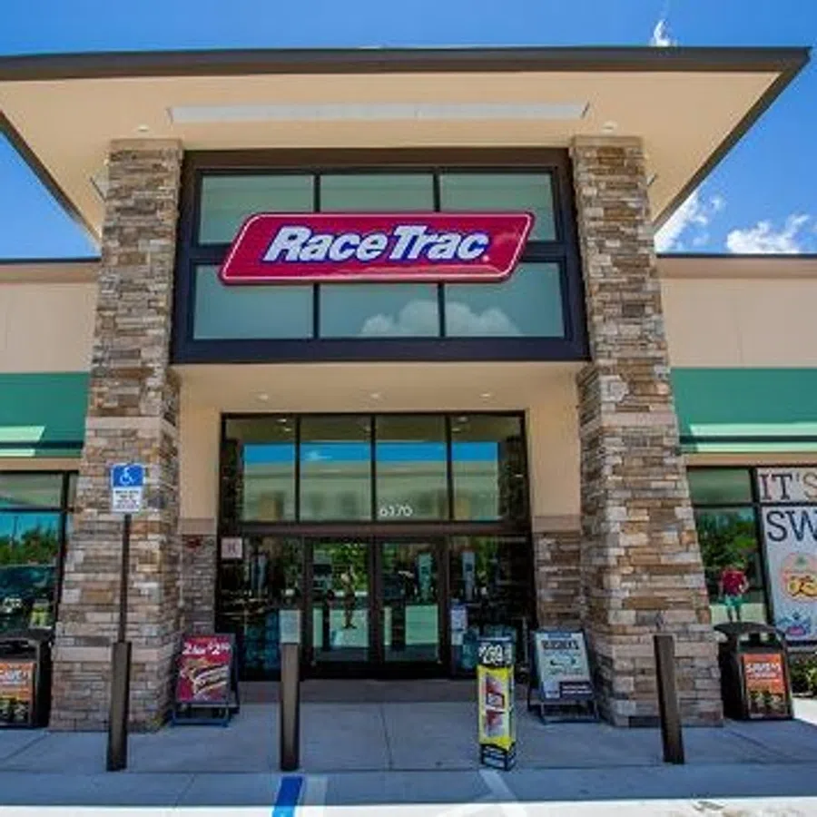 Exterior view of a RaceTrac convenience store with stone pillars and large glass entrance under a clear sky.