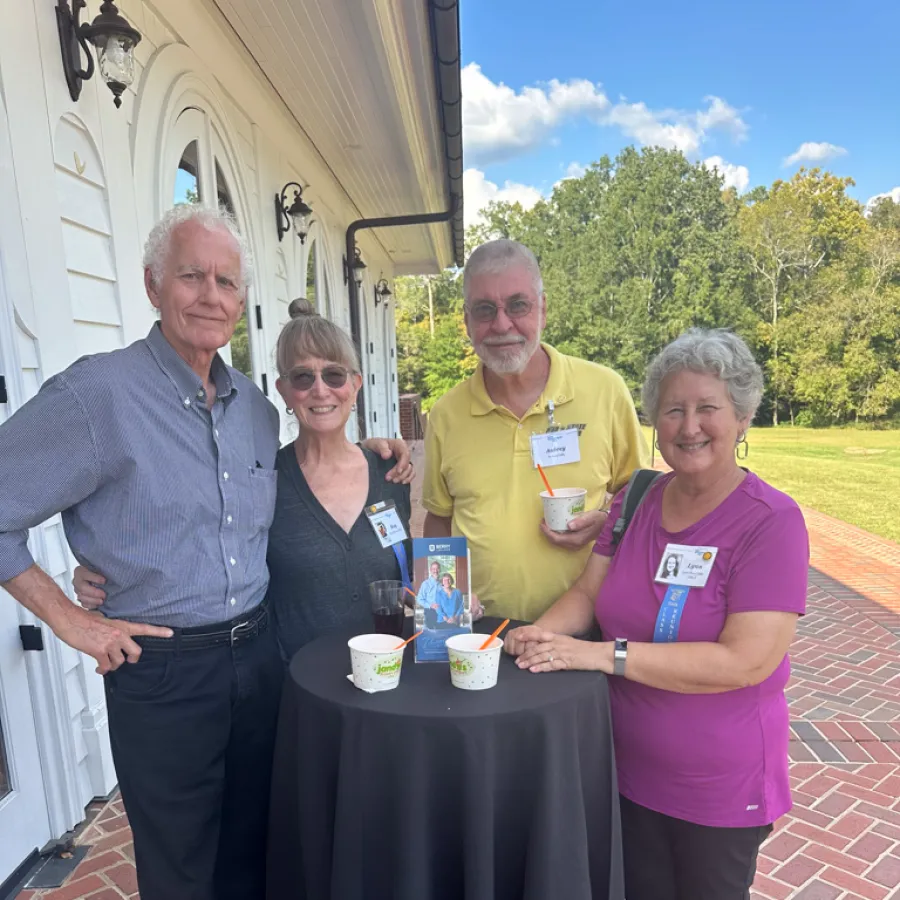 a group of people standing around a table with cups on it