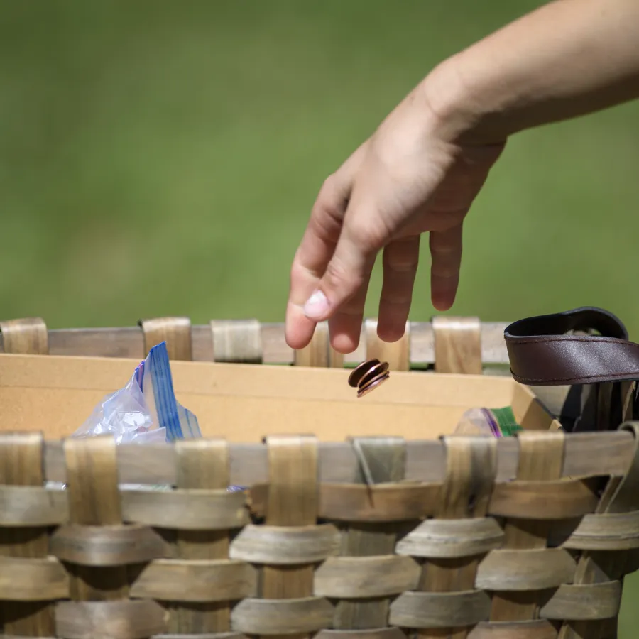 a hand pushing a cart full of coins