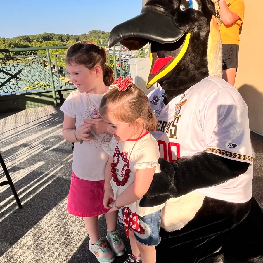 a person and a couple of children standing next to a person in a horse garment