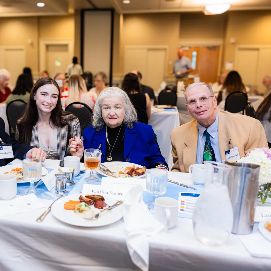 a group of people sitting at a table with food