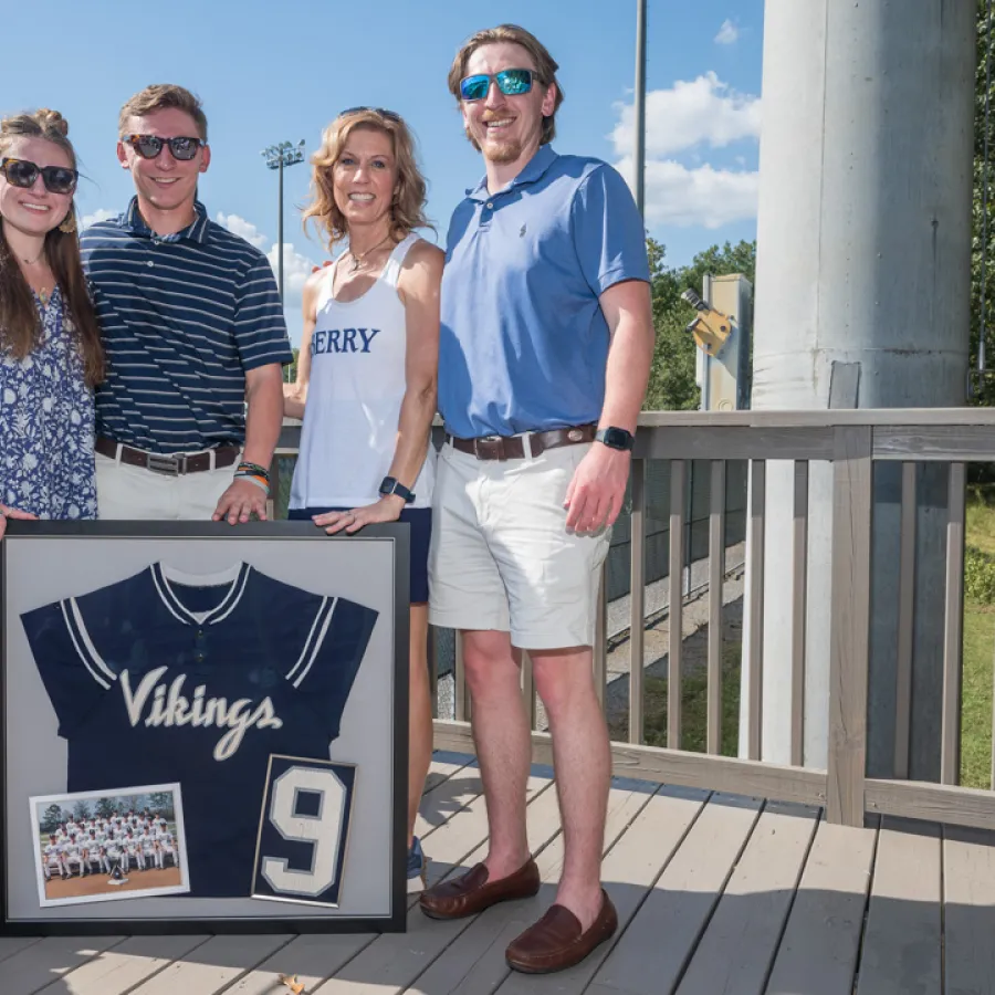 a group of people posing for a photo with a sign