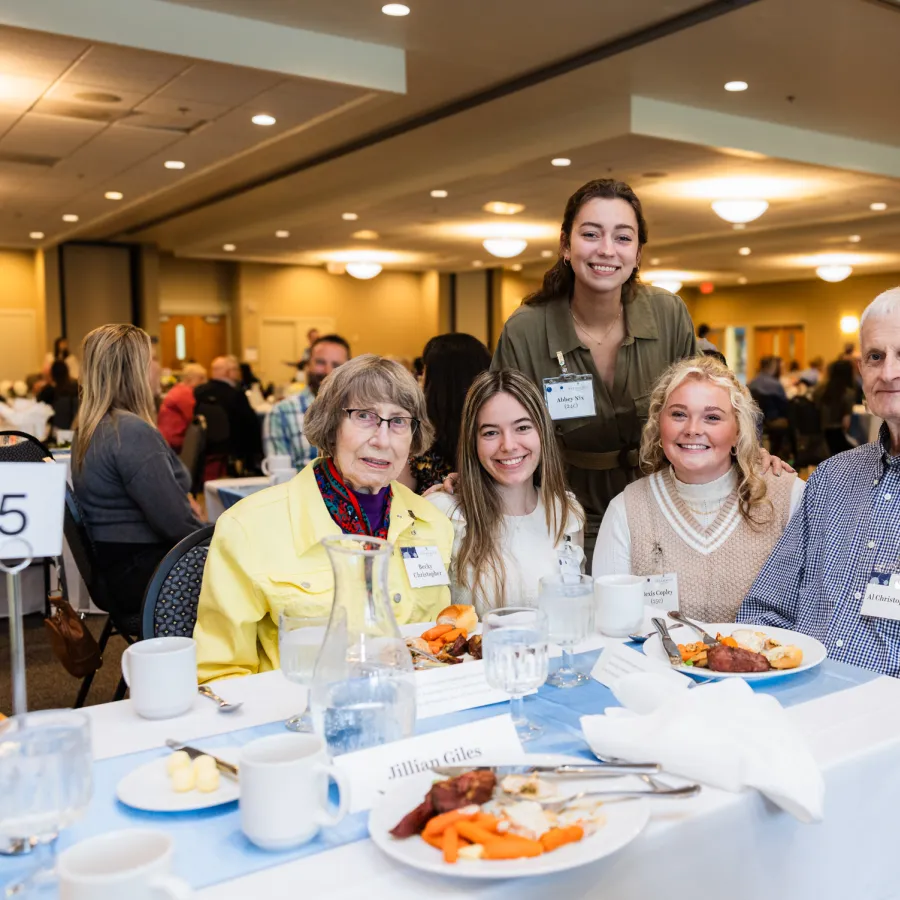 a group of people sitting at a table with food