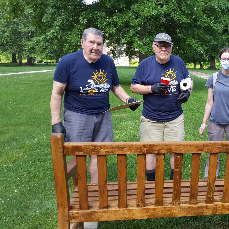 a group of people standing on a bench with a baseball bat