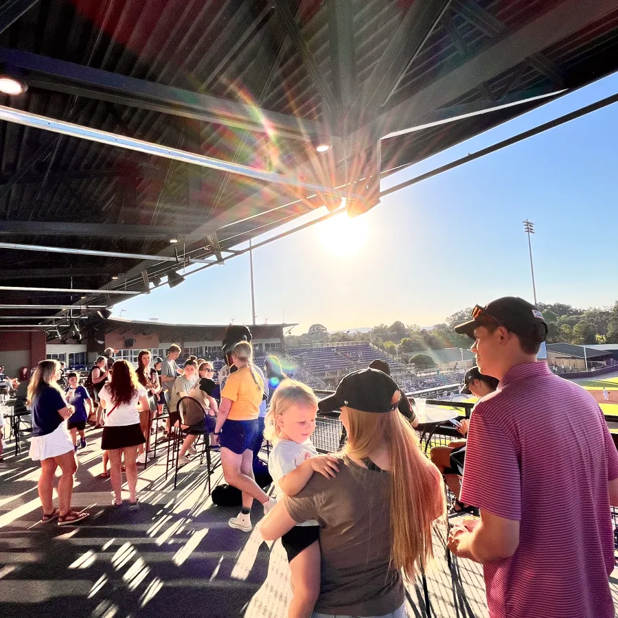 a group of people walking on a walkway under a bridge