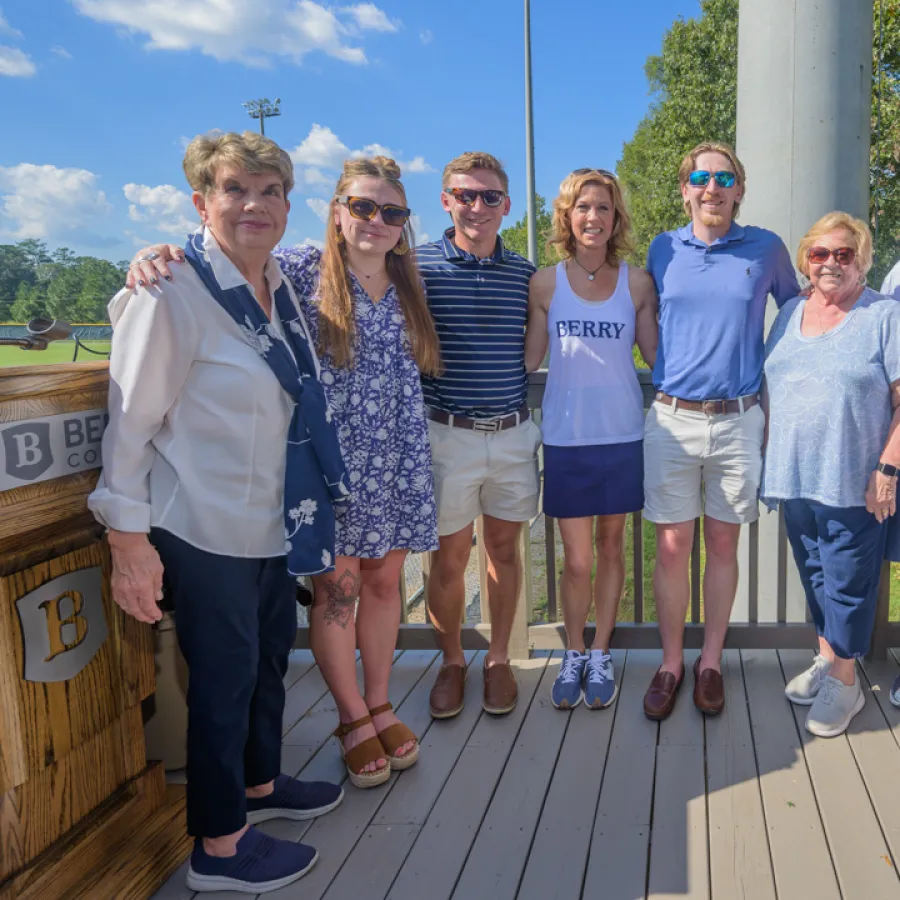 a group of people posing for a photo on a deck