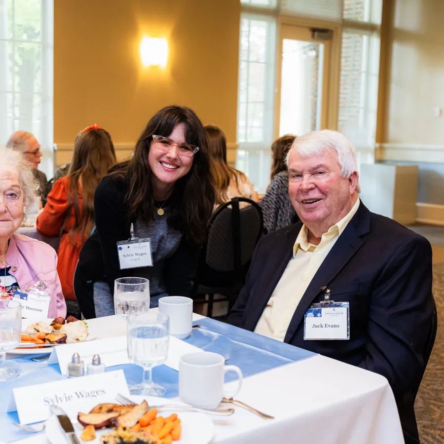 a group of people sitting at a table with food