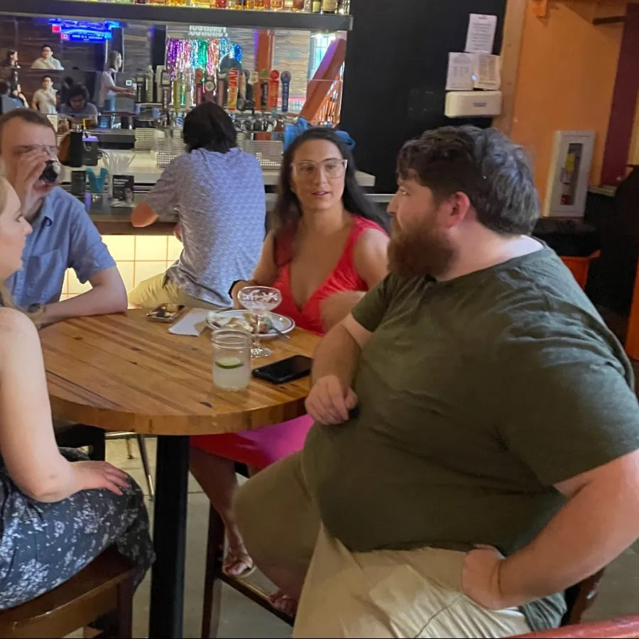 a man and a woman sitting in a chair in a bar