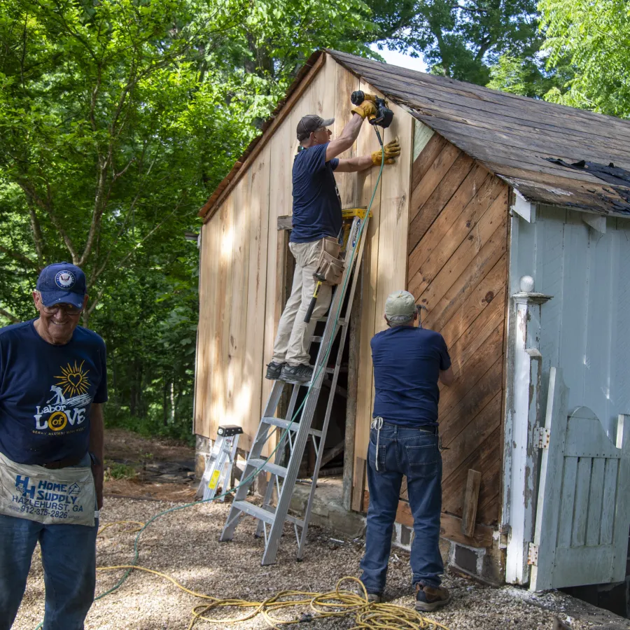a group of men working on a house