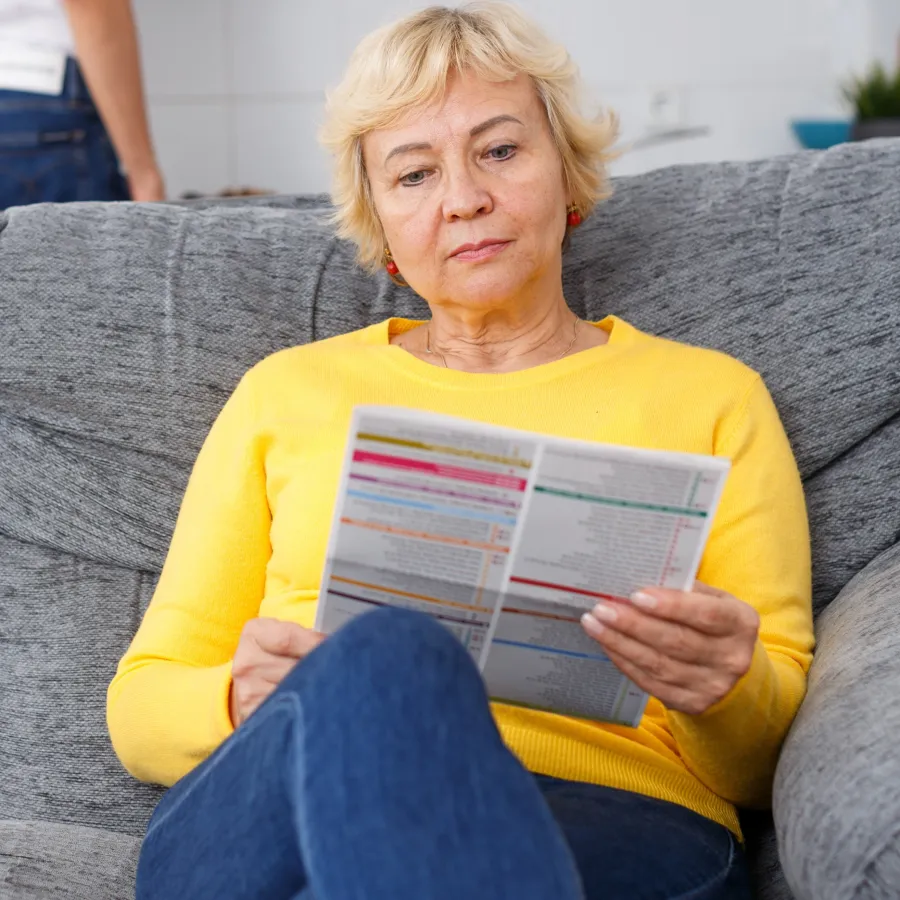 A woman reading a Printed Newsletter
