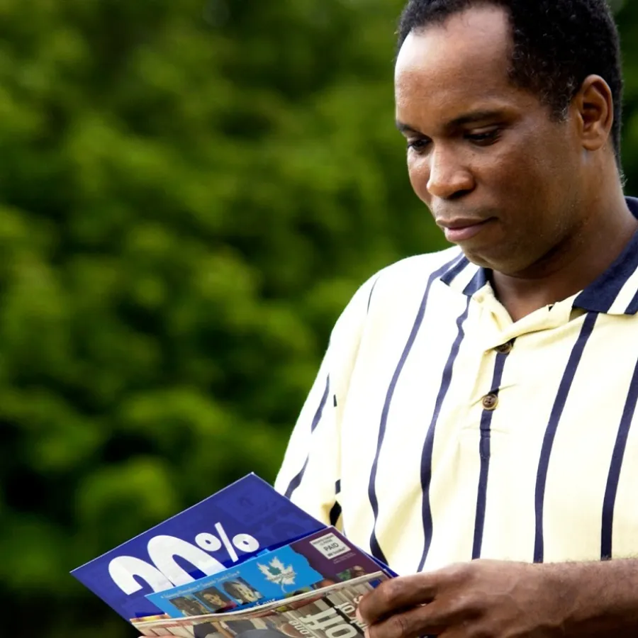 A man holding advertising Postcards he received in the mail