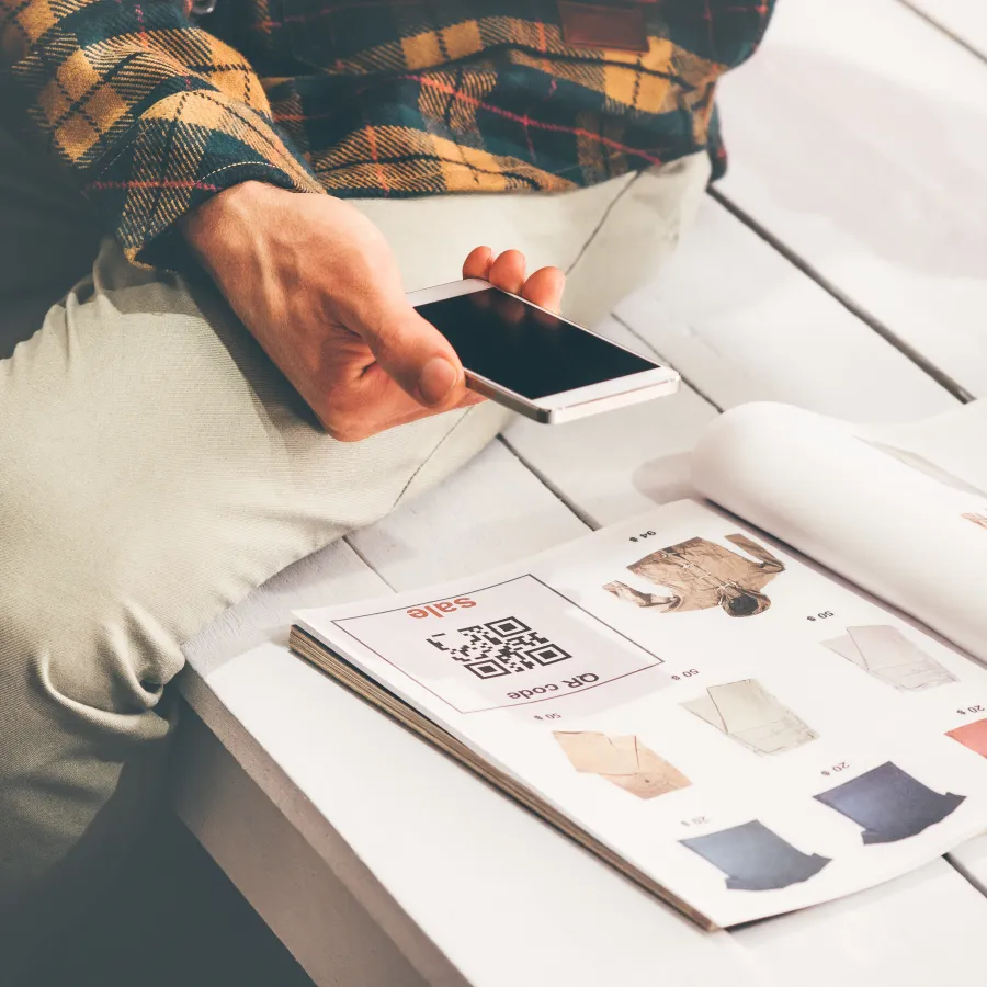 A man scanning a QR code printed in a Catalog