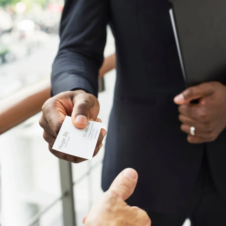 A man handing his Business Card to another man
