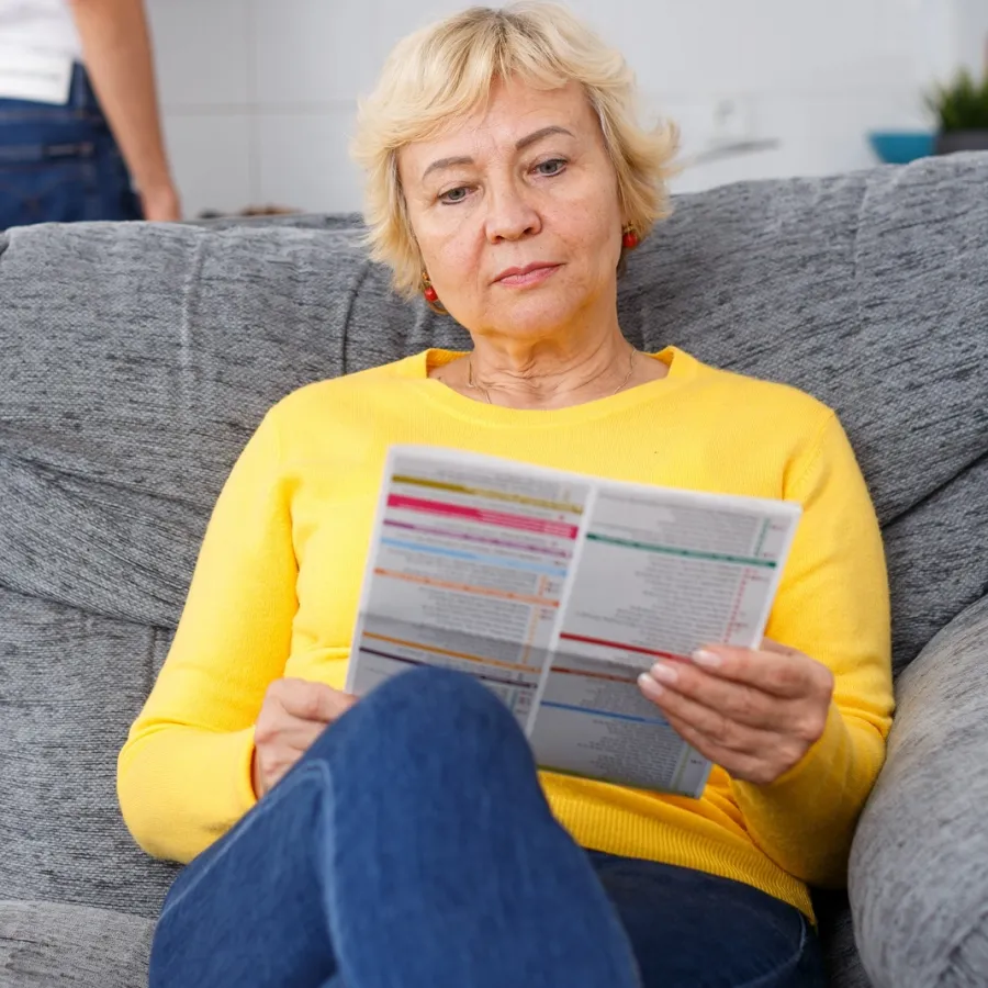A woman reading a Printed Newsletter