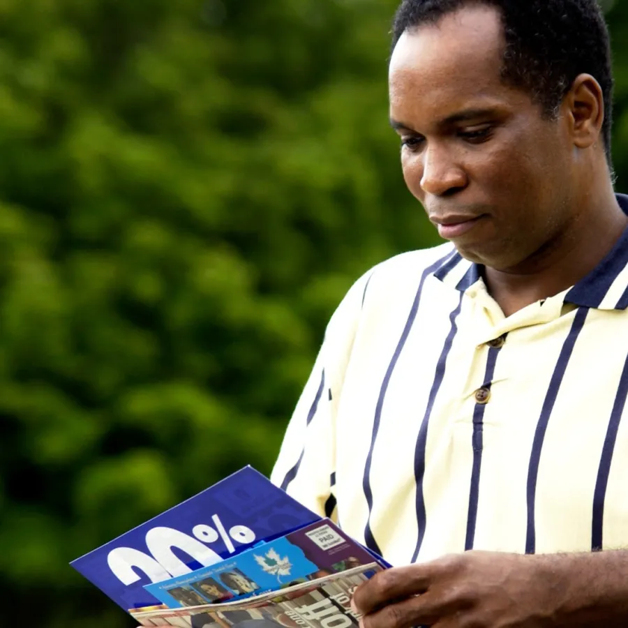 A man holding advertising Postcards he received in the mail