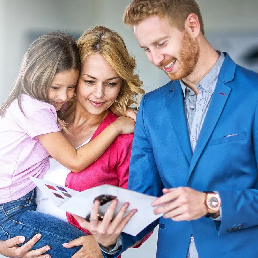 A man, a woman, and a child looking at a brochure