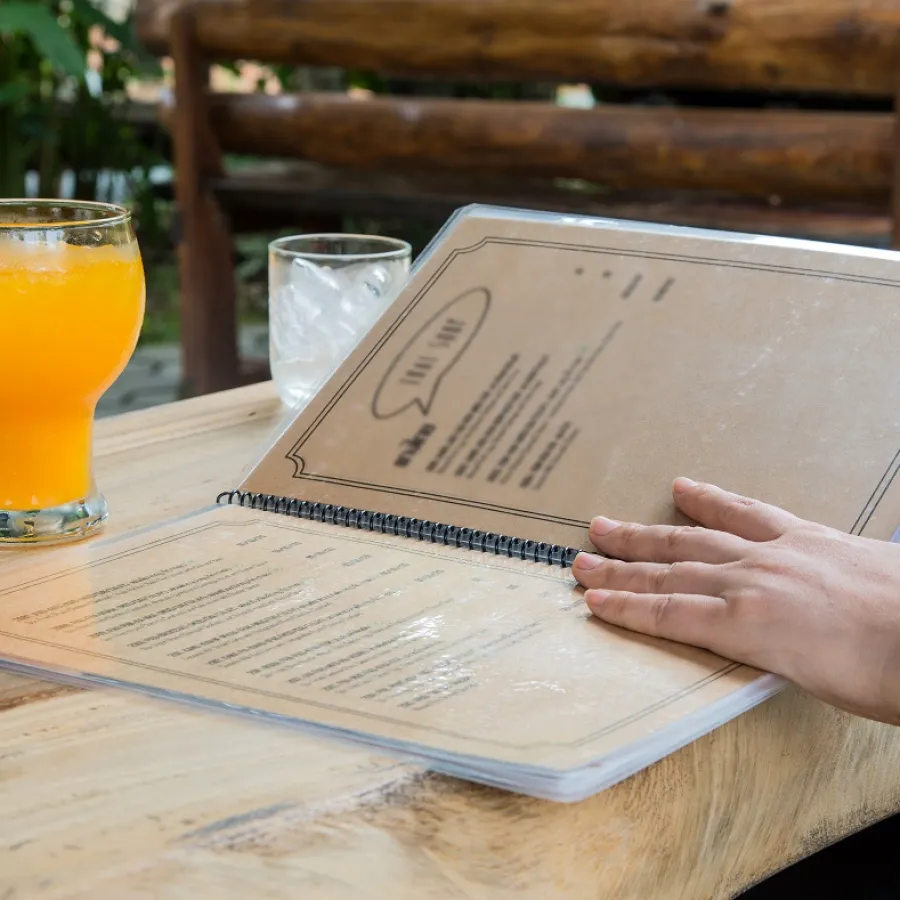 A person reading a Spiral Bound restaurant Menu