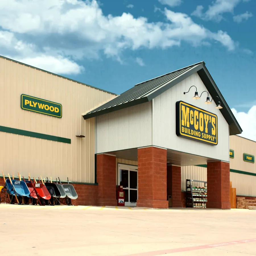 McCoy's Building Supply store exterior with stacked wheelbarrows and clear sky background