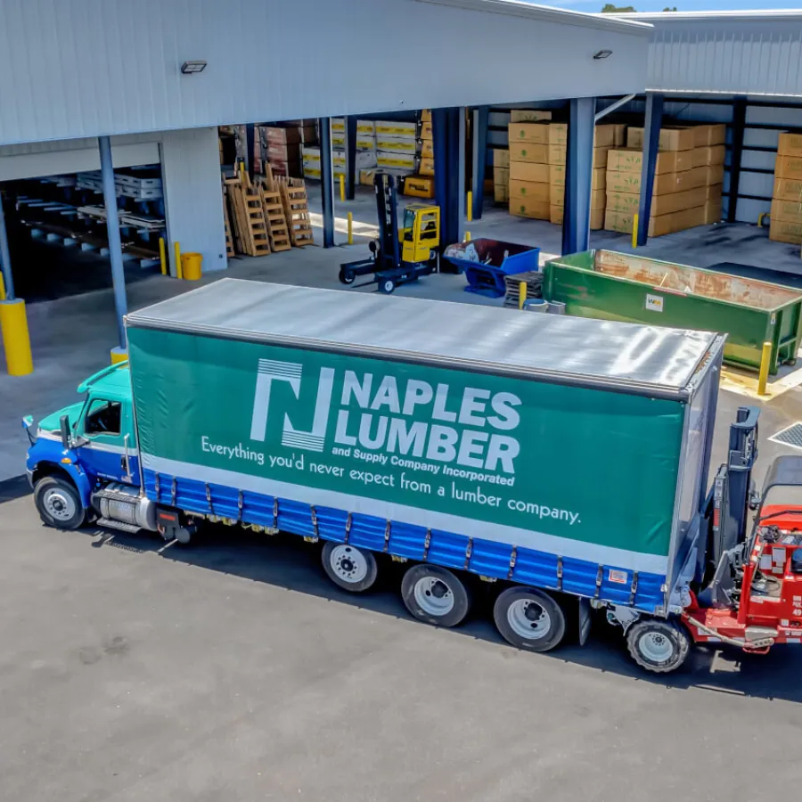 Large outdoor metal storage racks filled with pipes and materials under a blue sky at an industrial yard.