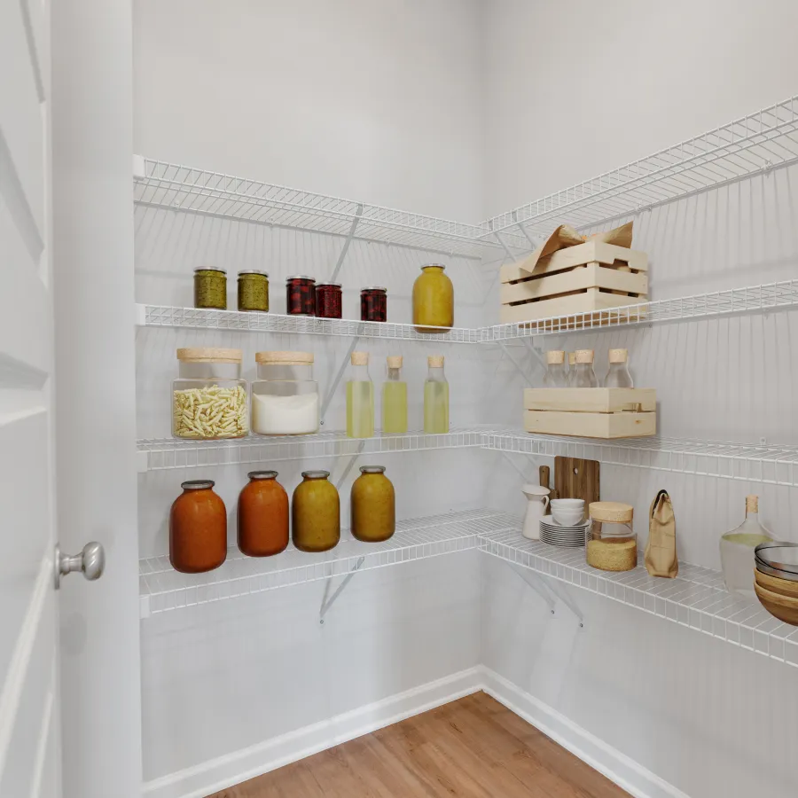 Organized pantry with white wire shelves holding jars, bottles, wooden crates, and kitchenware on wood floor.