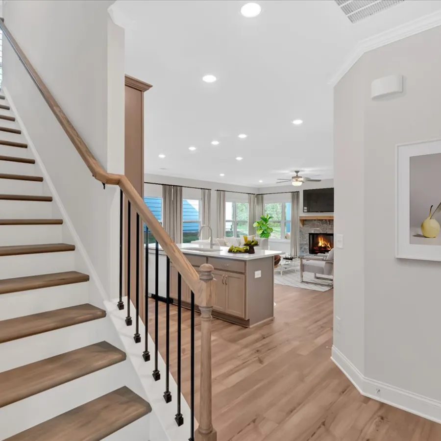 Bright modern interior featuring a staircase leading to a cozy living area with large windows.