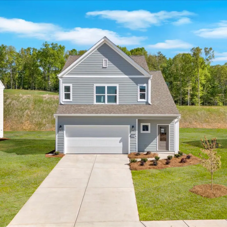 Modern two-story gray house with white trim, garage, and a manicured lawn under a blue sky.