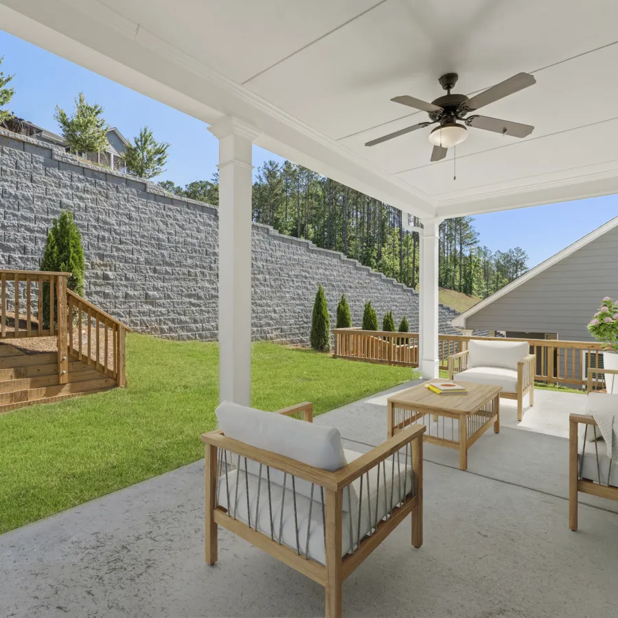 a house with a patio and a large stone wall