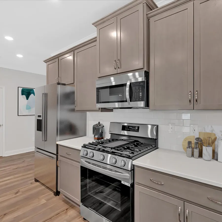 Modern kitchen featuring stainless steel appliances and sleek cabinetry with wooden flooring.