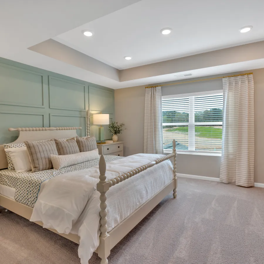 Bright modern bedroom with a cozy bed, soft colors, and stylish decor, featuring a large window and natural light.