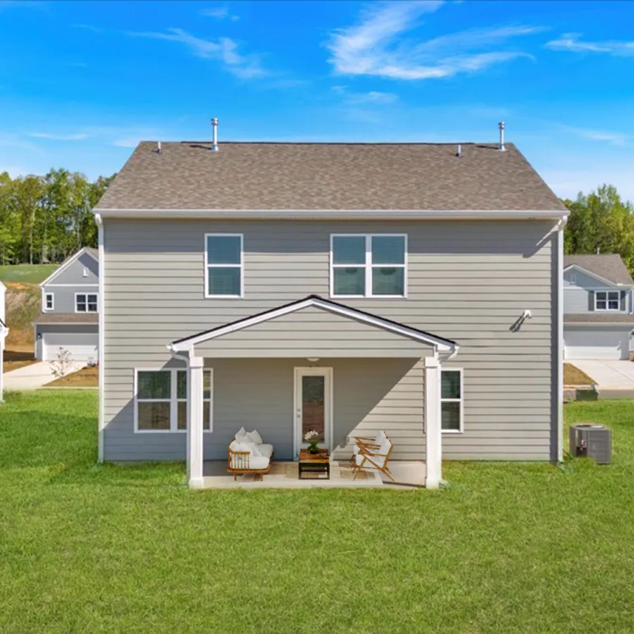 Spacious gray house with porch and green lawn in a residential neighborhood.