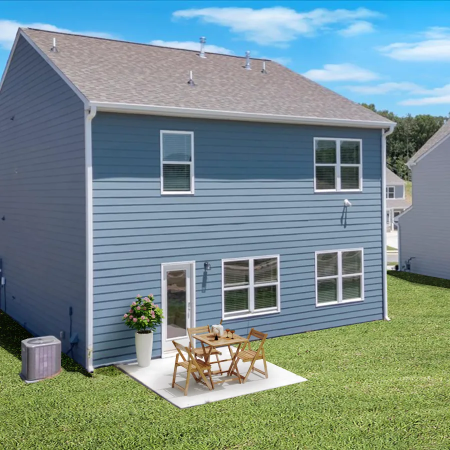 Blue two-story house with a small patio and outdoor furniture on a green lawn under blue sky