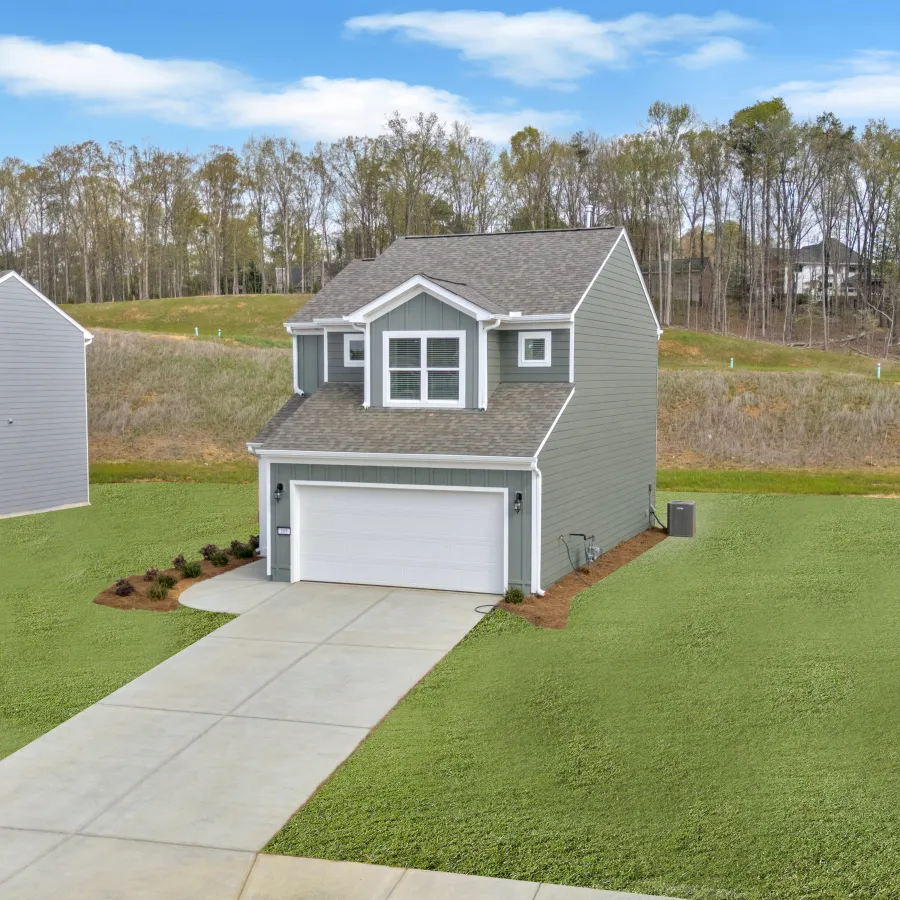 Contemporary two-story house with a landscaped yard and clear blue sky backdrop.