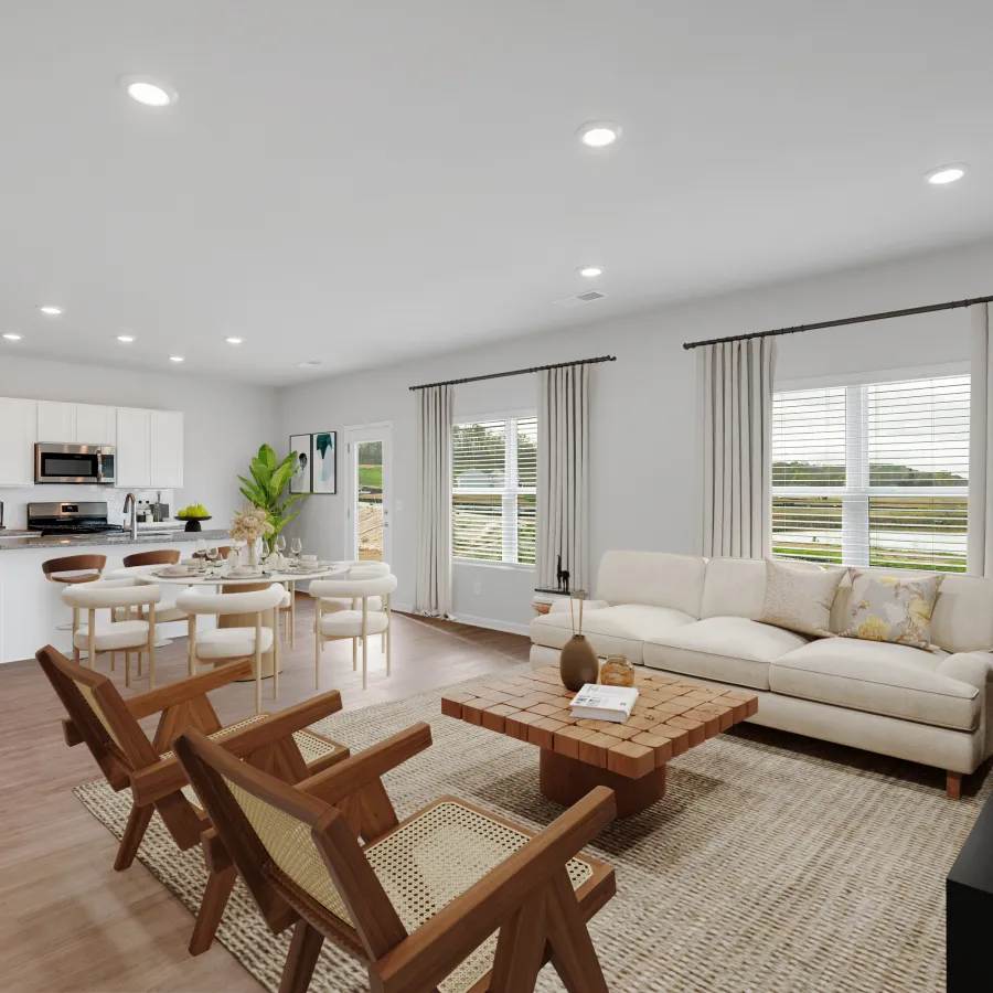 Modern living room and kitchen with natural light, stylish furniture, and contemporary decor.