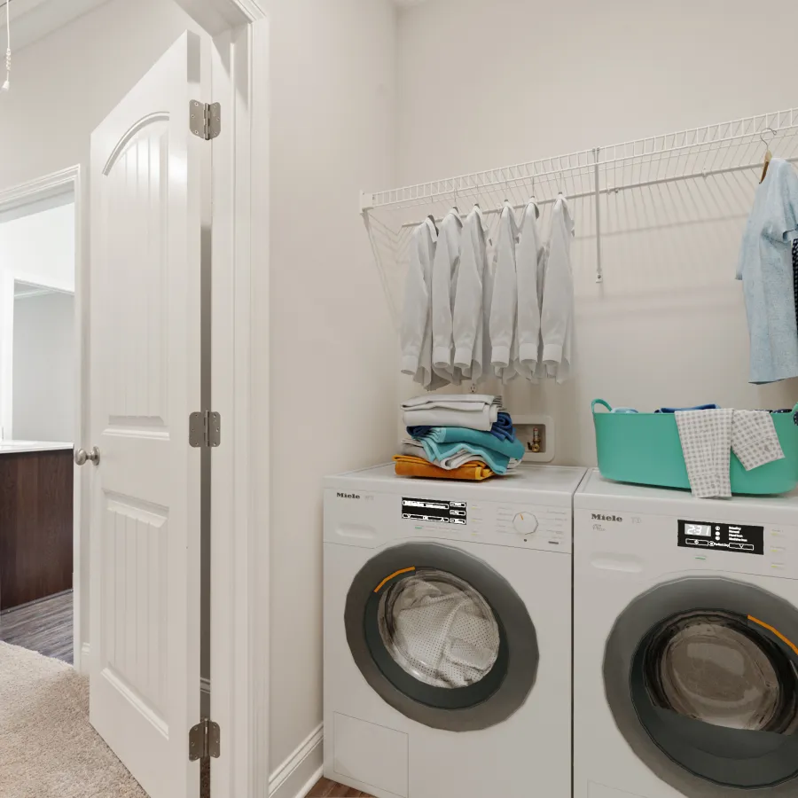 a laundry room with a washing machine and towels on the wall