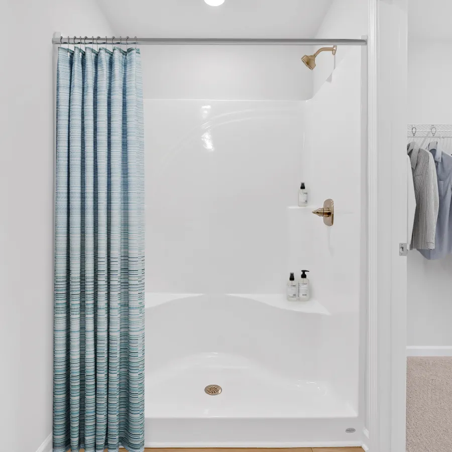Modern bathroom design featuring a glass shower and stylish blue shower curtain.
