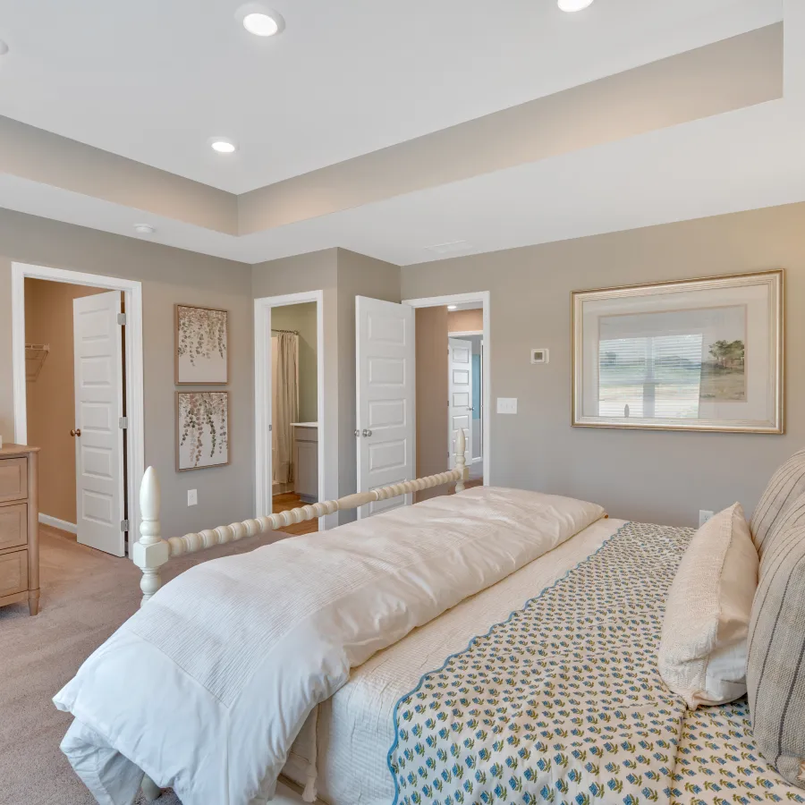Modern bedroom interior with neutral tones, cozy bedding, and stylish decor elements.