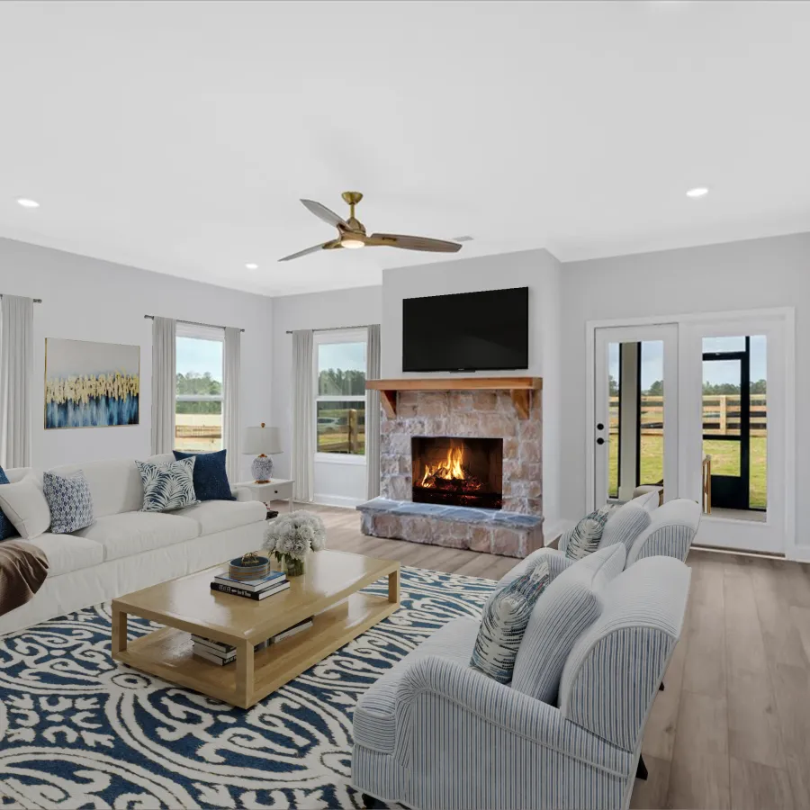 Spacious modern living room with a stone fireplace, large windows, blue patterned rug, and cozy seating arrangement.