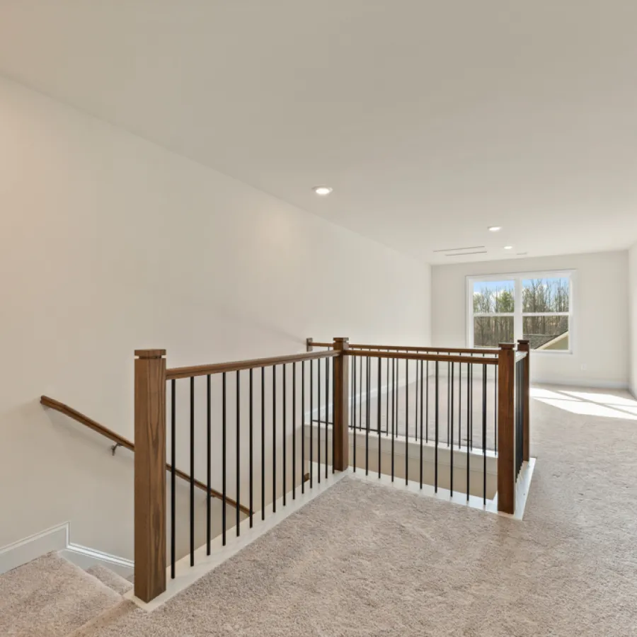 a large white room with a wood railing and a window