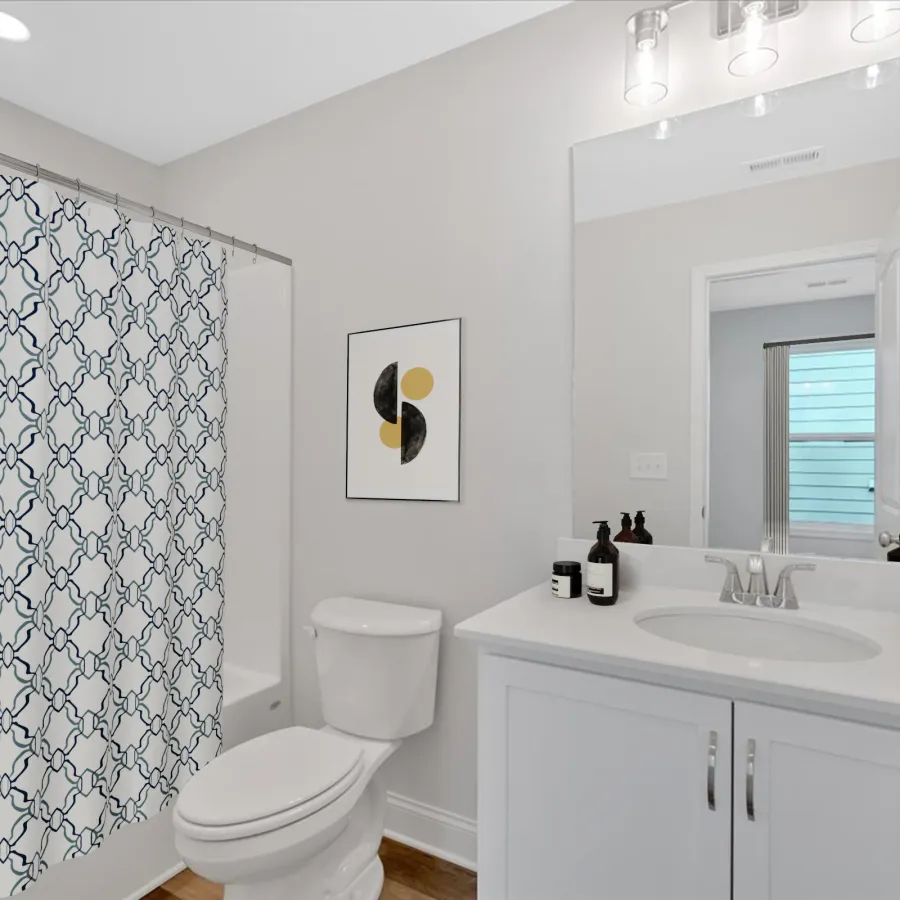 Bright bathroom with patterned shower curtain, modern sink, and stylish décor for a clean look.