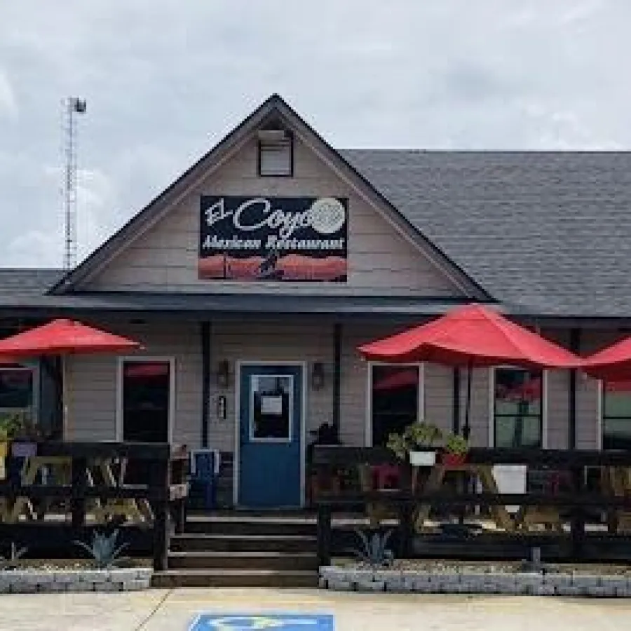 El Coyote Mexican restaurant with outdoor seating and red umbrellas on a sunny day.