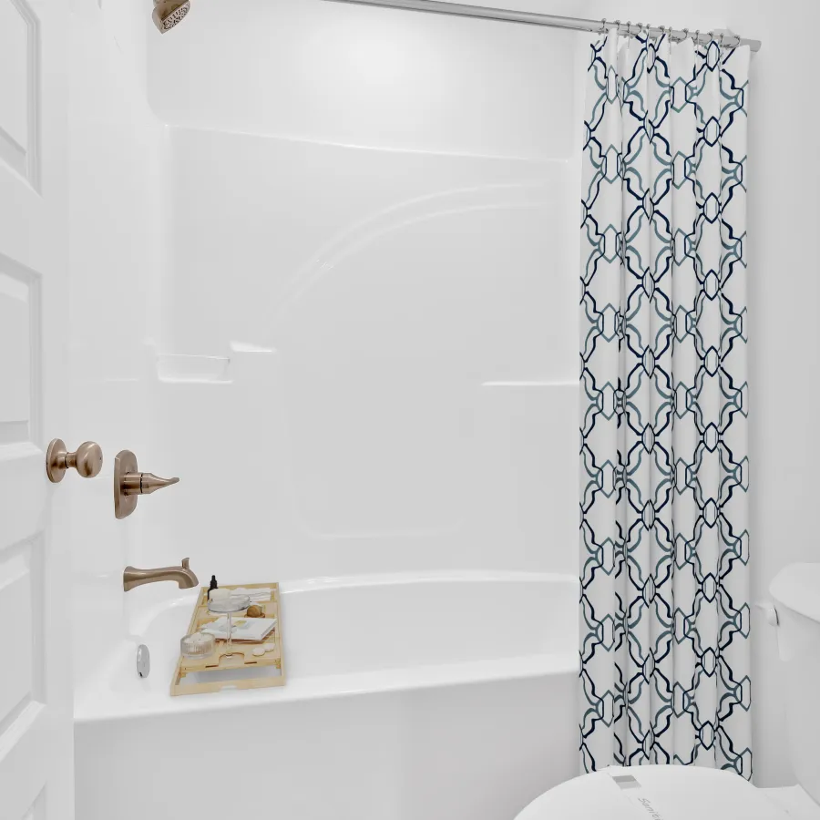 Bright, modern bathroom with a bathtub, shower, and decorative curtain.