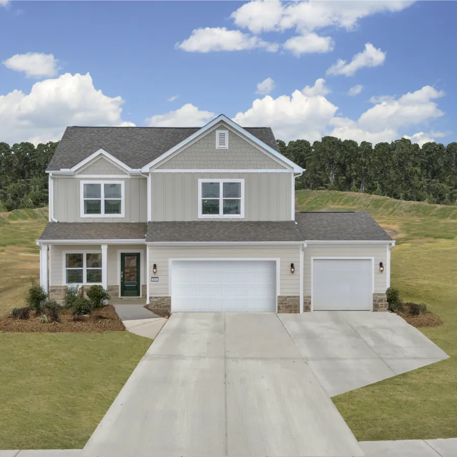 Modern two-story house with a landscaped yard under a clear blue sky.