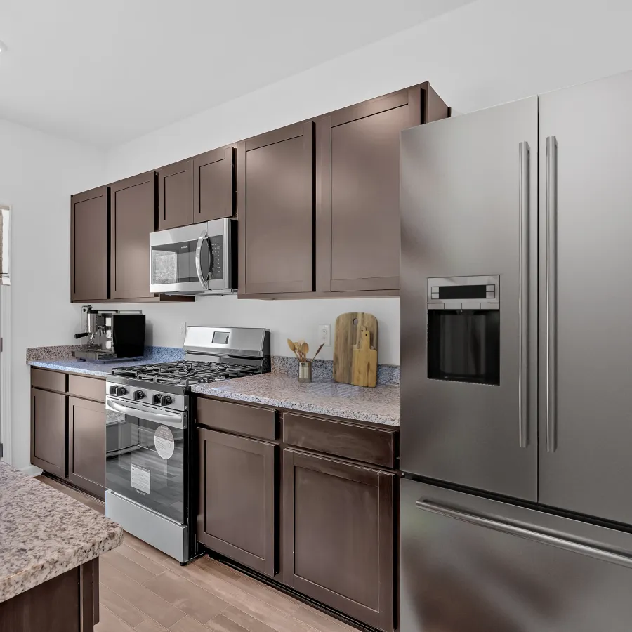 Modern kitchen featuring stainless steel appliances and dark wood cabinetry.
