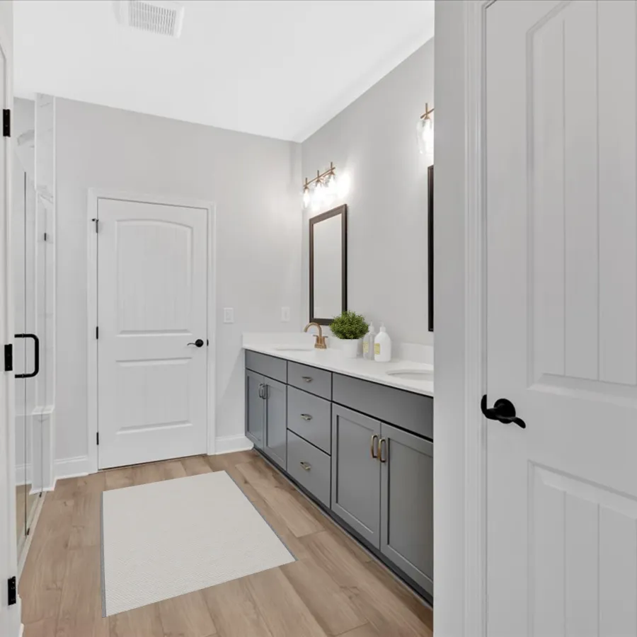 Modern bathroom interior with gray cabinets, double sinks, and wood-look flooring under soft lighting