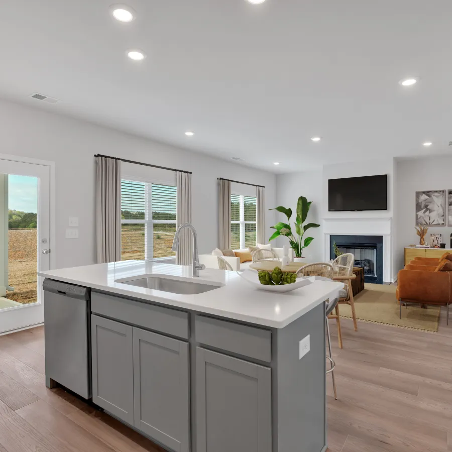 Modern open-concept living room and kitchen with a large island, gray cabinets, and minimalist decor.