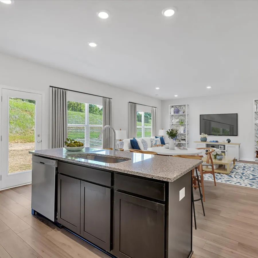 Modern open concept kitchen and living room with dark island, hardwood floors, and bright windows