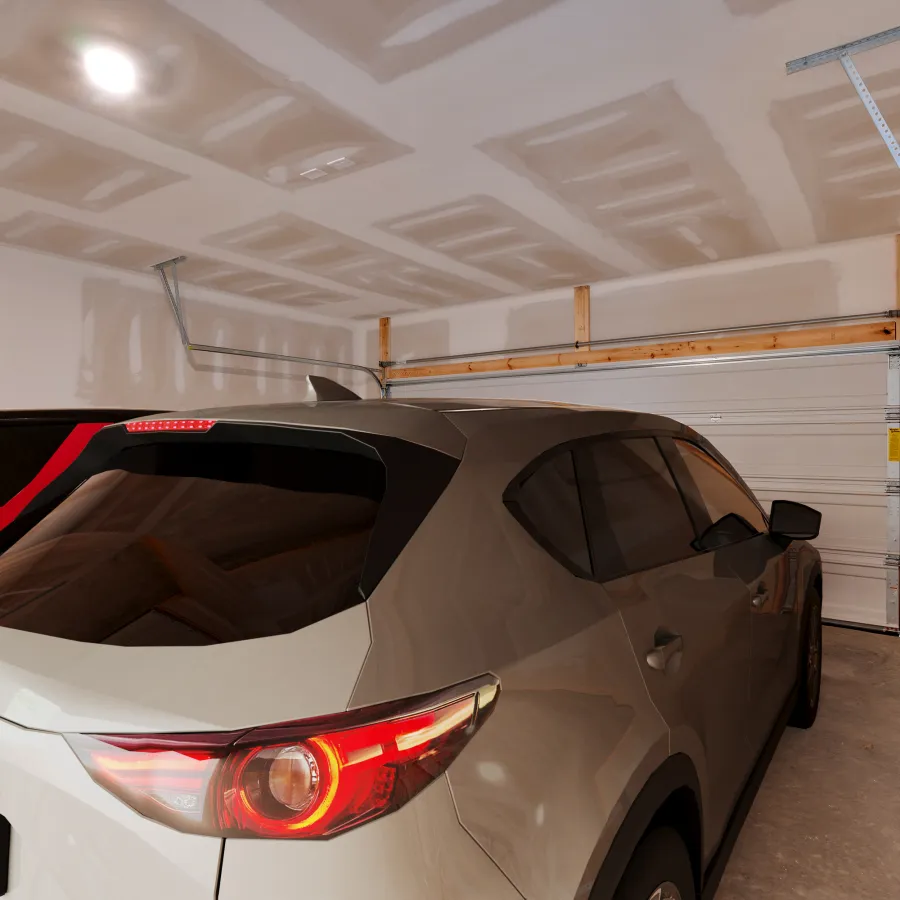 Two cars parked inside a spacious, unfinished garage with exposed drywall.