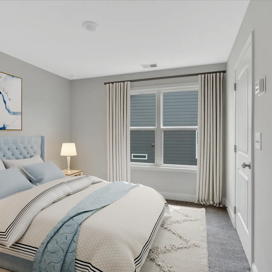 Bright bedroom with a tufted blue headboard, modern bedding, a bedside lamp, and abstract wall art under soft lighting.